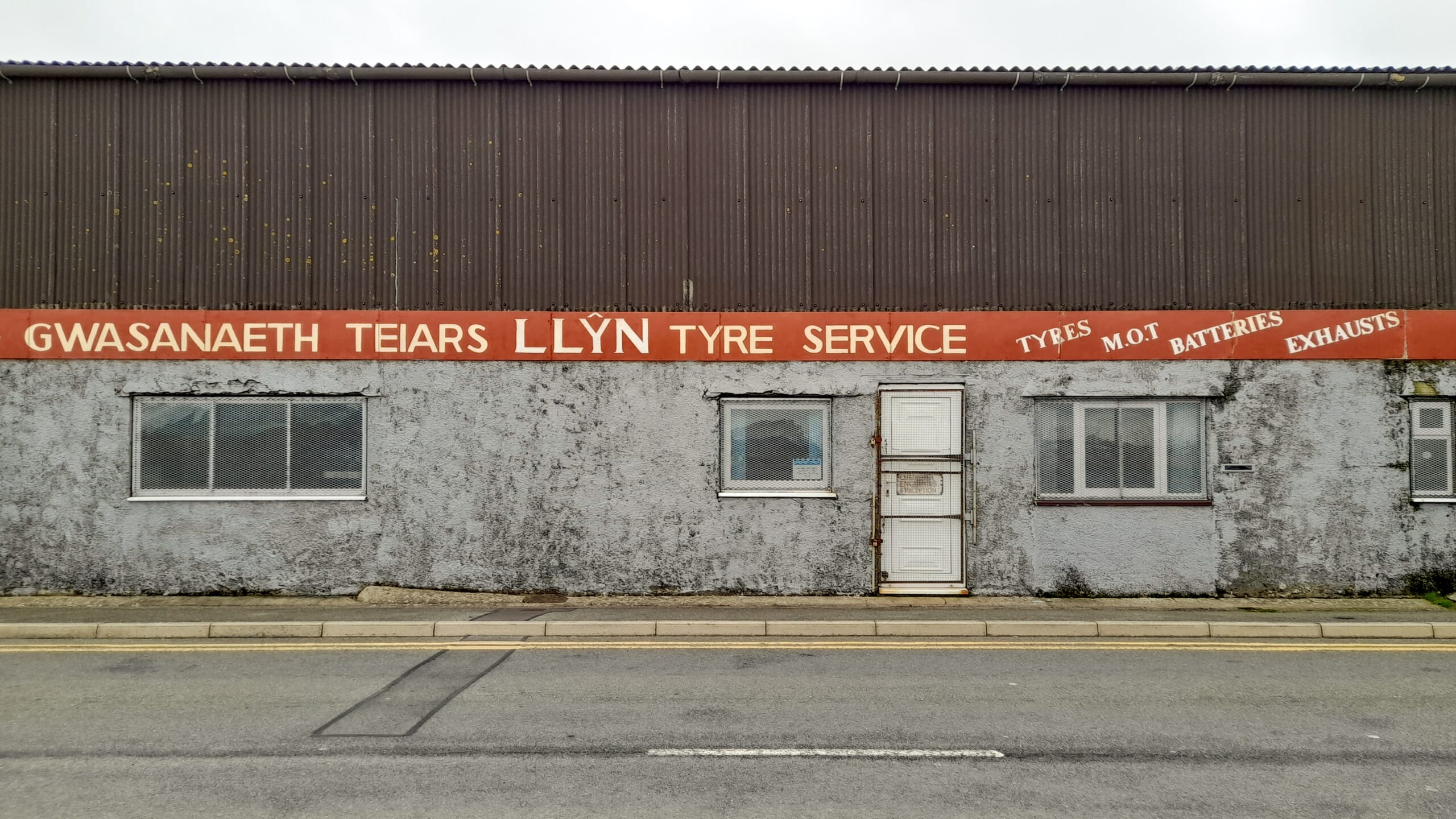 Former tyre and service garage in Pwllheli before works began, prior to its retrofit into Musclemorph Private Gym